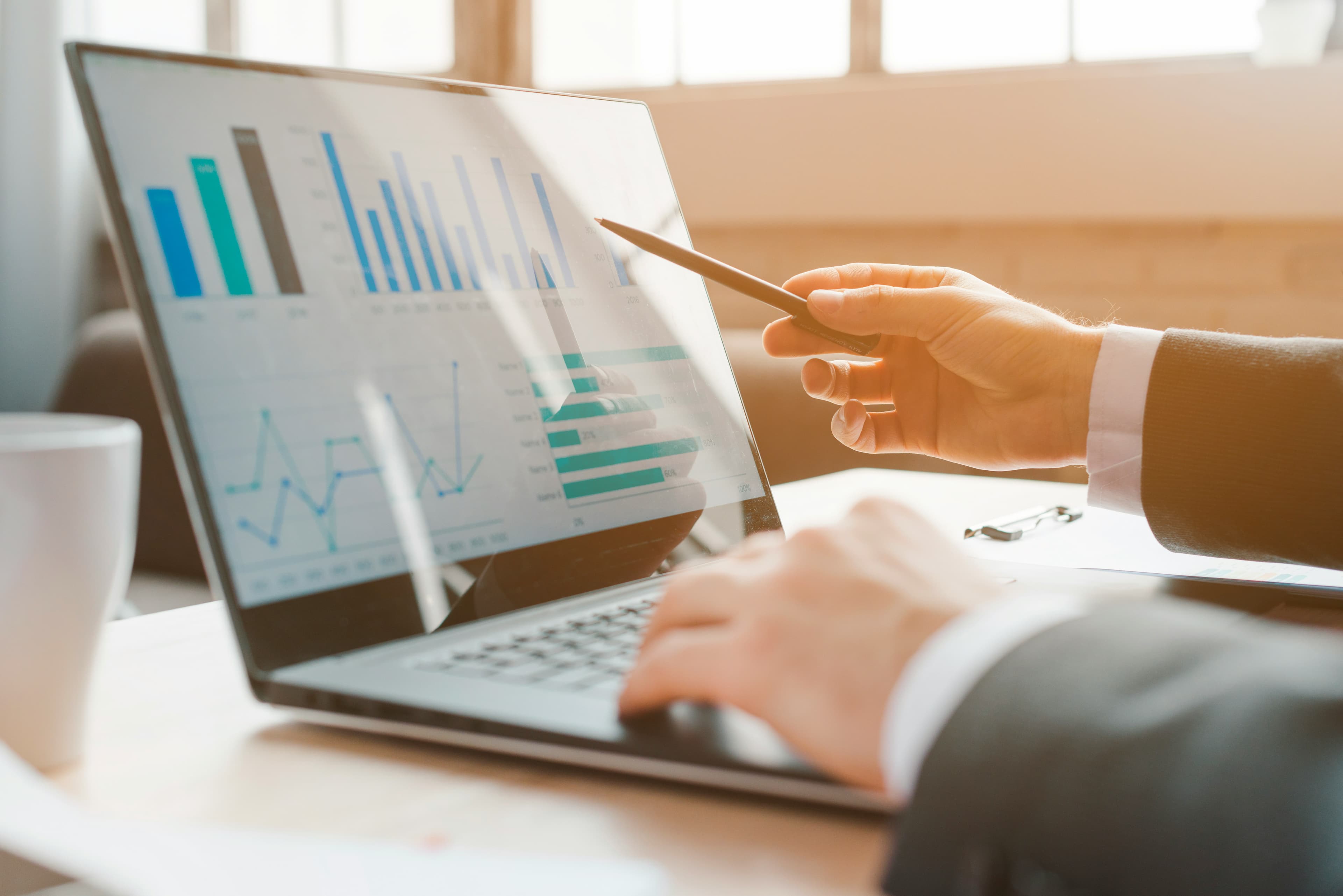 Professional reviewing analytics charts on a laptop
